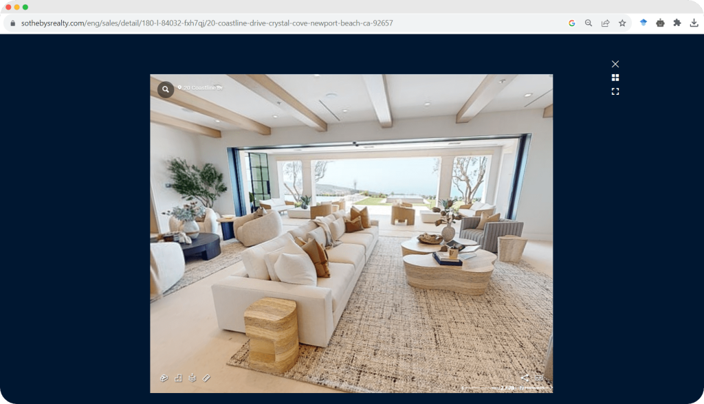 A spacious, elegantly furnished living room with large windows opening to a scenic outdoor view.